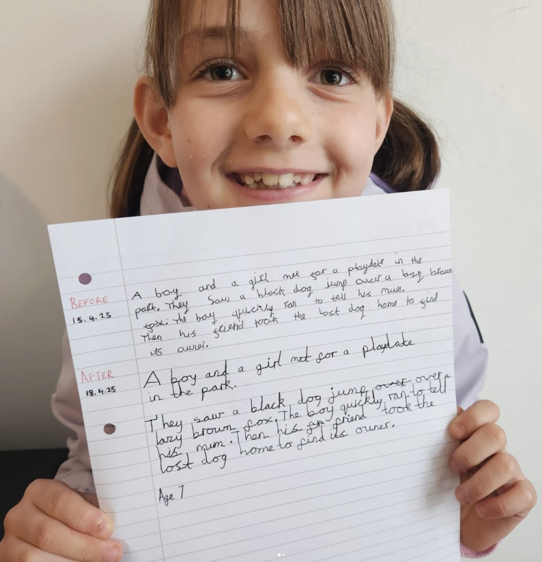 A smiling pupil holding up her handwriting sheet showing her before and after samples